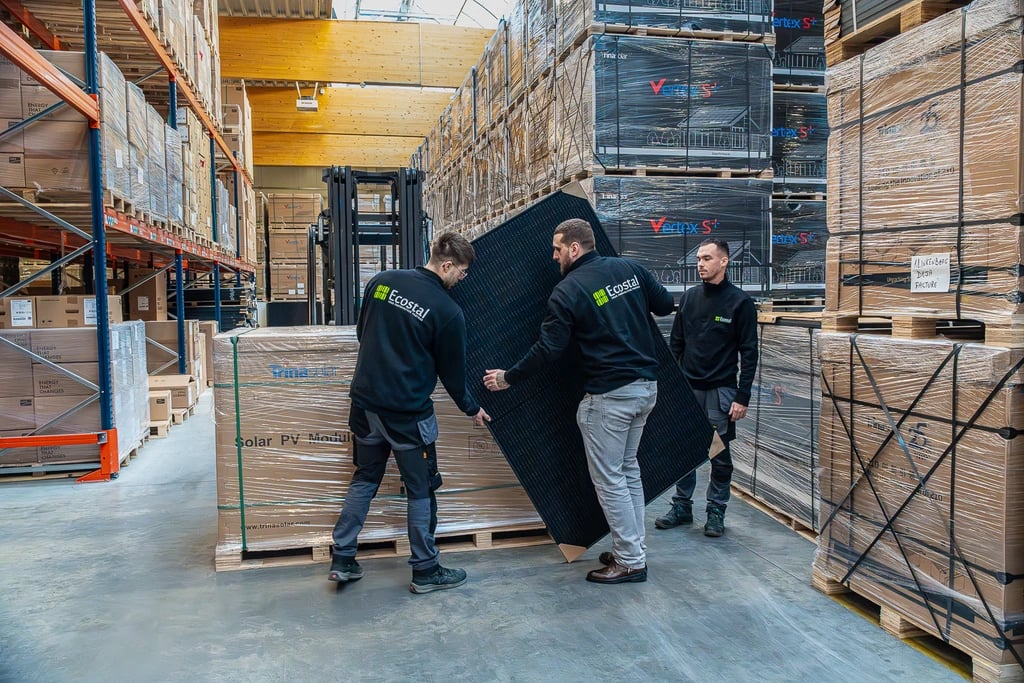 Équipe Ecostal Group manipulant un panneau photovoltaïque en entrepôt